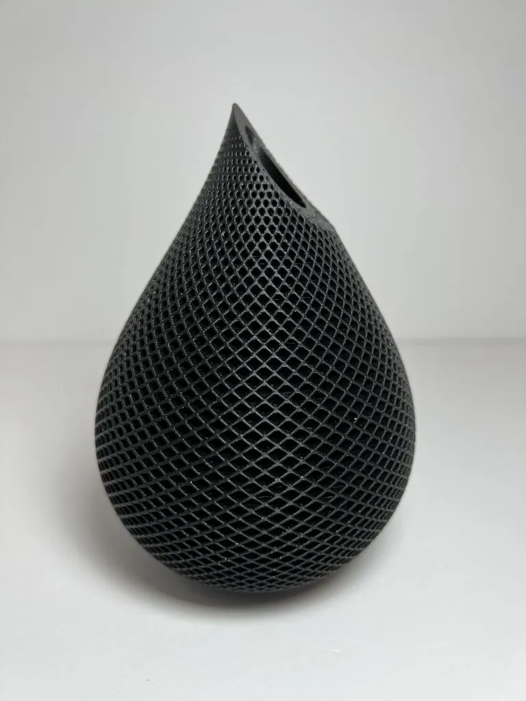 A black teardrop-shaped Voronoi vase with an open lattice surface.